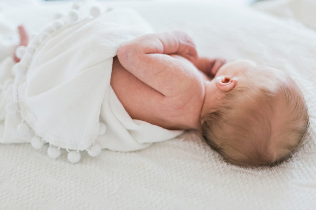 sleeping baby covered in white cloth