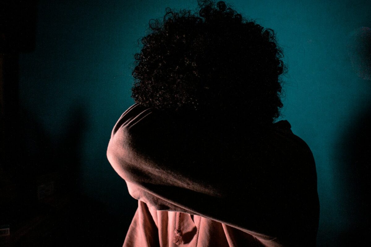 a woman wrapped in a blanket in a dark room